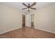 Bright bedroom with wood-look flooring, a ceiling fan, and access to the ensuite bathroom at 7420 W Los Gatos Dr, Glendale, AZ 85310