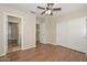Spacious bedroom with wood-look floors, a ceiling fan, and an adjoining room and closet at 7420 W Los Gatos Dr, Glendale, AZ 85310