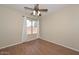 Inviting bedroom with wood-look flooring, a ceiling fan, and bright natural light through the window at 7420 W Los Gatos Dr, Glendale, AZ 85310