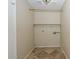 Walk-in closet with neutral walls, a single shelf, a wooden railing, and diamond-patterned floors at 7420 W Los Gatos Dr, Glendale, AZ 85310