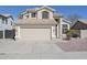Inviting home showcasing a two-car garage, desert landscaping, and a neutral color palette at 7420 W Los Gatos Dr, Glendale, AZ 85310