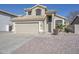 Beige two-story home with desert landscaping, tan garage door and tan roof at 7420 W Los Gatos Dr, Glendale, AZ 85310