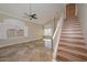 Bright living room with a ceiling fan, tile flooring, and staircase access at 7420 W Los Gatos Dr, Glendale, AZ 85310