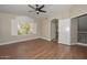 Spacious main bedroom featuring a ceiling fan, wood floors, and a large window for ample natural light at 7420 W Los Gatos Dr, Glendale, AZ 85310