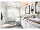 Modern bathroom featuring double sink, glass walk-in shower with stone pebble flooring, and ample natural light at 7508 N 21St St, Phoenix, AZ 85020
