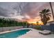 Tranquil backyard with a sparkling swimming pool and comfortable lounge chairs under a vibrant sunset at 7508 N 21St St, Phoenix, AZ 85020