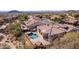 Aerial view of home with a sparkling pool and backyard oasis, surrounded by desert landscape and mountain views at 8041 E Teton Cir, Mesa, AZ 85207