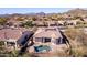 Stunning aerial view of a home with a backyard pool, located in a scenic desert community with mountain vistas at 8041 E Teton Cir, Mesa, AZ 85207