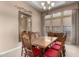Formal dining room featuring wood table with red cushioned chairs, chandelier and a decorative mirror enhancing the space at 8041 E Teton Cir, Mesa, AZ 85207