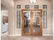 Inviting entryway with wood framed glass panel doors and sidelight windows, creating a bright and welcoming ambiance at 8041 E Teton Cir, Mesa, AZ 85207