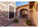 Cozy courtyard featuring brick pavers, stone accents, and a welcoming arched doorway at 8041 E Teton Cir, Mesa, AZ 85207