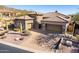 Stunning home featuring multiple garages, stone accents, desert landscaping, and a brick paved driveway at 8041 E Teton Cir, Mesa, AZ 85207