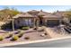 Charming single-story home featuring a tile roof, stone accents, desert landscaping, and a paved driveway at 8041 E Teton Cir, Mesa, AZ 85207