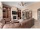 Warm living room with built-in shelving and cabinets, fireplace, and a comfortable leather couch and ottoman at 8041 E Teton Cir, Mesa, AZ 85207