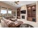 Cozy living area features custom built-ins surrounding a fireplace, plus a large window overlooking desert landscaping at 8041 E Teton Cir, Mesa, AZ 85207