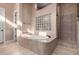 Relaxing main bathroom featuring a soaking tub, a glass block window, and a separate shower area at 8041 E Teton Cir, Mesa, AZ 85207