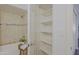 Bright bathroom with storage shelves, a bathtub with a shower, and decorative tile at 9990 N Scottsdale Rd # 2020, Paradise Valley, AZ 85253