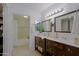 Bathroom with dual sinks, mirrors, and dark wood cabinets at 9990 N Scottsdale Rd # 2020, Paradise Valley, AZ 85253
