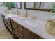 Bathroom featuring dual sinks with quartz countertops and dark wood cabinets at 9990 N Scottsdale Rd # 2020, Paradise Valley, AZ 85253