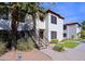 Two-story condo building with red tile roof, exterior stairs, and green landscaping at 9990 N Scottsdale Rd # 2020, Paradise Valley, AZ 85253
