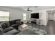 Comfortable living room featuring a large gray sectional, modern entertainment center with fireplace, and tile floors at 1018 S 5Th St, Avondale, AZ 85323