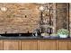 Custom bar area with stone accent wall, black countertop, and glass shelving at 10224 N Azure Vista Trl, Fountain Hills, AZ 85268