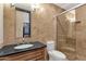 Elegant bathroom with tan tile walls, a glass shower door, and dark countertop at 10224 N Azure Vista Trl, Fountain Hills, AZ 85268