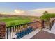 Picturesque view from the patio featuring wrought iron railings overlooking lush green golf course and distant desert landscape at 10224 N Azure Vista Trl, Fountain Hills, AZ 85268