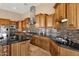 Gourmet kitchen featuring custom wood cabinets, stainless steel appliances, and black countertops at 10224 N Azure Vista Trl, Fountain Hills, AZ 85268