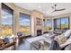 Well-lit living room showcasing a stone fireplace, comfortable seating, and picturesque views of the surrounding landscape at 10224 N Azure Vista Trl, Fountain Hills, AZ 85268