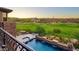 Elevated view of the luxurious pool area with integrated spa and stone water feature, overlooking a beautifully maintained golf course at 10224 N Azure Vista Trl, Fountain Hills, AZ 85268