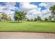 Scenic golf course view featuring lush green grass, mature trees, and a beautiful blue sky with fluffy clouds at 10511 W Wheatridge Dr, Sun City, AZ 85373