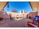 Fully furnished patio with an intricate stone floor, stone walls, and umbrellas providing shade at 10511 W Wheatridge Dr, Sun City, AZ 85373