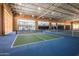 Indoor pickleball court featuring a well-maintained green and blue surface, net, and bright lighting at 10511 W Wheatridge Dr, Sun City, AZ 85373