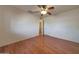 Bedroom featuring hardwood floors, white walls, and a ceiling fan at 10650 W Riviera Dr, Sun City, AZ 85351