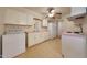 Cozy kitchen with tile floor, white cabinetry, appliances, and laundry appliances at 10650 W Riviera Dr, Sun City, AZ 85351