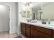 Bathroom features a double sink vanity with a decorative mirror and modern light fixture at 10983 W Mckinley St, Avondale, AZ 85323