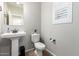 Comfortable half bath features a pedestal sink, decorative mirror, and a window with plantation shutters at 10983 W Mckinley St, Avondale, AZ 85323