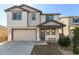 Charming two-story home features a beige exterior, covered entry, two-car garage, and manicured landscaping at 10983 W Mckinley St, Avondale, AZ 85323