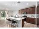 Modern kitchen with white countertops, brown cabinets, stainless steel appliances, and breakfast bar seating at 10983 W Mckinley St, Avondale, AZ 85323