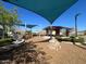 Community playground featuring wood mulch, shade structures, a climbing structure, and seating at 10983 W Mckinley St, Avondale, AZ 85323