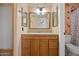 Bathroom featuring a wood vanity with granite counters, framed mirror, and decorative wall paper at 11955 W Granada Rd, Avondale, AZ 85392