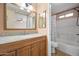 Bathroom featuring a wood vanity with granite counters, framed mirror, and tub shower combo at 11955 W Granada Rd, Avondale, AZ 85392