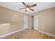 A cozy bedroom featuring a ceiling fan, wood-look flooring, and a closet for storage at 11955 W Granada Rd, Avondale, AZ 85392