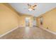 Spacious living room features tile flooring, light yellow walls, ceiling fan, and multiple access points at 11955 W Granada Rd, Avondale, AZ 85392