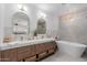 Bright bathroom with dual vanity, quartz countertops, modern fixtures, and a soaking tub at 12236 N 59Th St, Scottsdale, AZ 85254