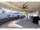 Outdoor kitchen and dining area with grill, ceiling fans, and shade umbrella at 12236 N 59Th St, Scottsdale, AZ 85254