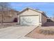 View of a desert landscape with a two-car garage and desert front yard at 12246 W Bloomfield Rd, El Mirage, AZ 85335