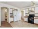 Open concept kitchen with white cabinets and black appliances at 12246 W Bloomfield Rd, El Mirage, AZ 85335