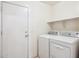 Clean laundry room featuring a washer and dryer set, and convenient access to the exterior at 12246 W Bloomfield Rd, El Mirage, AZ 85335